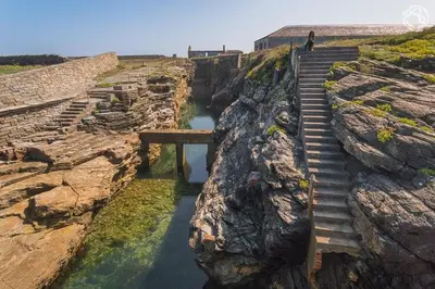 a person walking up a stairs on a cliff at Apartamento Rosalía de Castro Ribadeo in Ribadeo