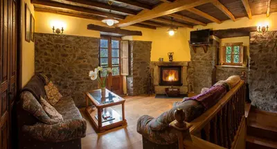 a living room with a couch and a fireplace at Casa de Aldea Vache in Naraval