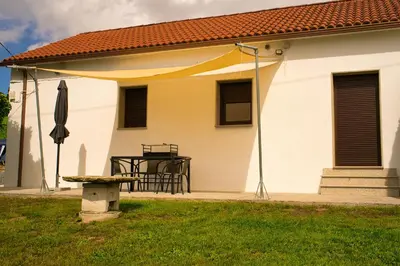 a white house with a table and a yellow canopy at a revolta Boqueixon in Lestedo
