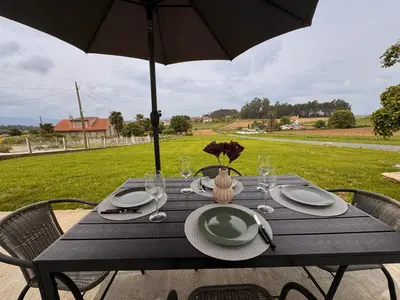 a wooden table with plates and an umbrella at a revolta Boqueixon in Lestedo