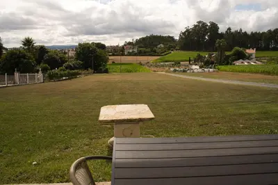 a bench sitting in a park with a field at a revolta Boqueixon in Lestedo