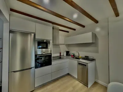 a kitchen with white cabinets and a stainless steel refrigerator at a revolta Boqueixon in Lestedo