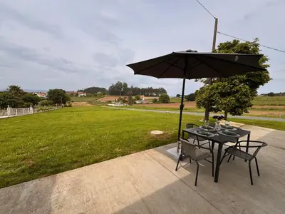 a table and chairs with an umbrella on a patio at a revolta Boqueixon in Lestedo