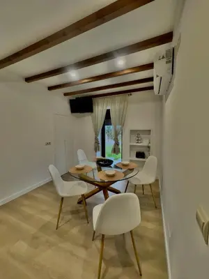 a dining room with a table and white chairs at a revolta Boqueixon in Lestedo