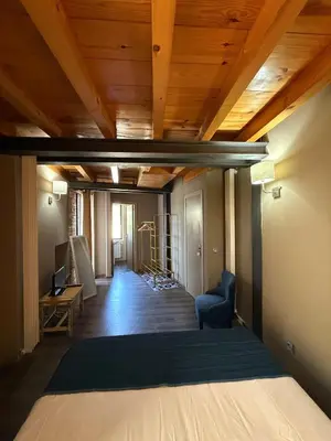 a hallway with wood ceilings and a living room at De Mamá in Molinaseca