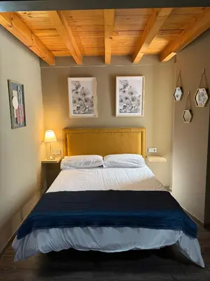 a bedroom with a large bed with a wooden headboard at De Mamá in Molinaseca