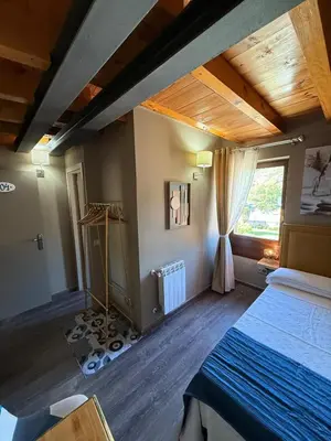 an attic room with a bed and a window at De Mamá in Molinaseca