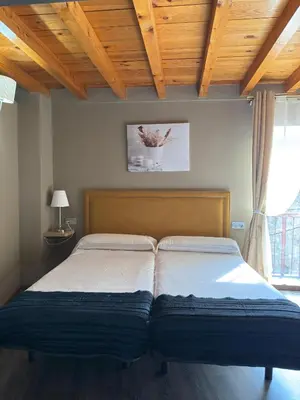 a bed in a bedroom with a wooden ceiling at De Mamá in Molinaseca
