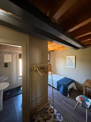 a bedroom with a bed and a room with a bathroom at De Mamá in Molinaseca