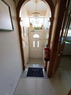 a room with a fireplace and a table and a door at Albergue Ultreia Sigueiro in Sigüeiro