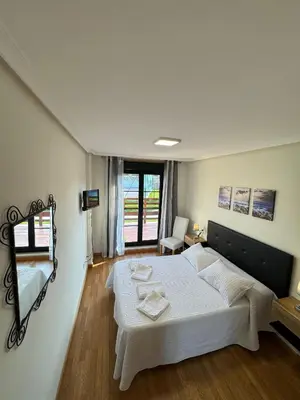 a bedroom with a large white bed and a window at Apartamento Rammari Spa in San Miguel de Reinante