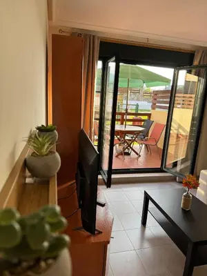 a living room with a television and a balcony at Apartamento Rammari Spa in San Miguel de Reinante