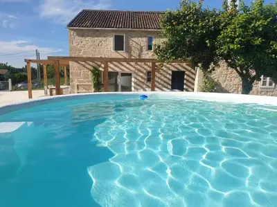 a large blue swimming pool in front of a house at Casa Castro in Lamas