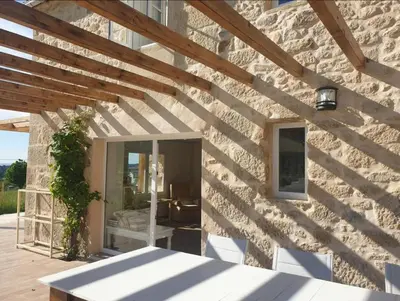 a stone house with a wooden ceiling and a patio at Casa Castro in Lamas