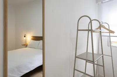 a mirror in a room with a bed and a ladder at Habitación en Apartamento Teo in Santiago de Compostela