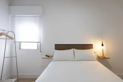 a bedroom with a white bed and a window at Habitación en Apartamento Teo in Santiago de Compostela