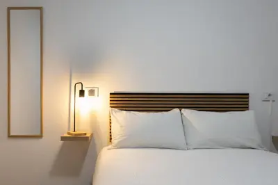 a bedroom with a white bed and a mirror at Habitación en Apartamento Teo in Santiago de Compostela