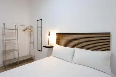 a bedroom with a white bed with a wooden headboard at Habitación en Apartamento Teo in Santiago de Compostela
