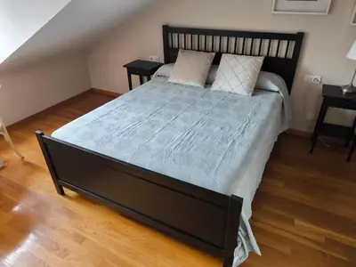 a bedroom with a large bed with two night stands at A&M Real Estate in Milladoiro