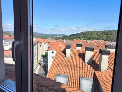 a view from a window of roofs of buildings at A&M Real Estate in Milladoiro