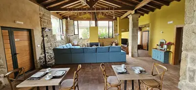 a living room with a table and a blue couch at Palleira da Meiroá in Esgos