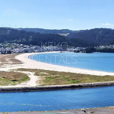 an island in a body of water with a city at Con Encanto en la Playa in Viveiro