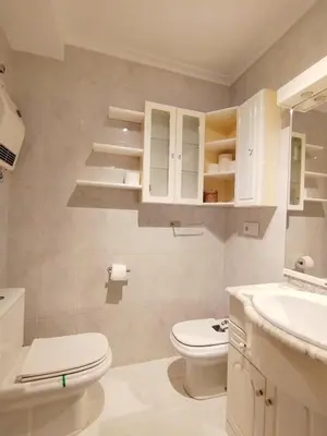 a white bathroom with a toilet and a sink at Con Encanto en la Playa in Viveiro