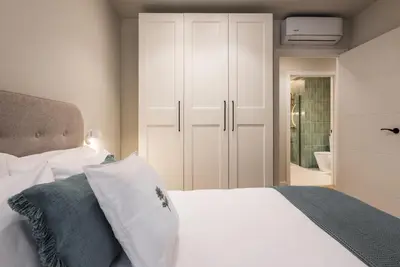 a bedroom with a white bed and a bathroom at Loft América 41 A in Melide