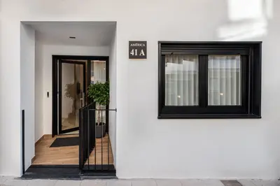 a white building with two windows and a doorway at Loft América 41 A in Melide