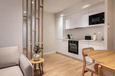 a living room with a table and a kitchen at Loft América 41 A in Melide