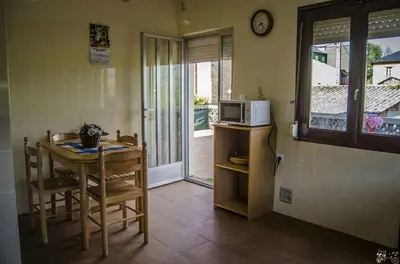 a small kitchen with a table and a microwave at Casa Rural El Cabo in Carucedo