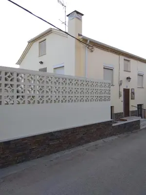 a white building with a fence on the side of it at Casa Rural El Cabo in Carucedo