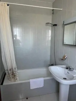 a bathroom with a tub and a sink and a shower at Hostal Delfino in Bardaos