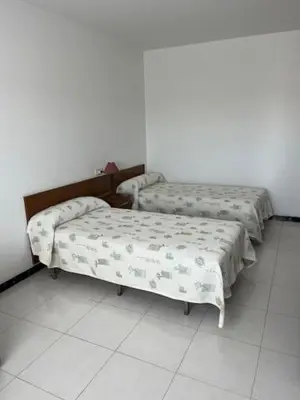 two beds sitting next to each other in a room at Hostal Delfino in Bardaos