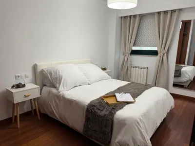 a bedroom with a bed with a book on it at Rei Túzaro in Milladoiro
