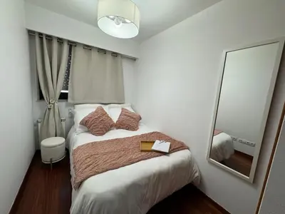 a small bedroom with a bed and a mirror at Rei Túzaro in Milladoiro