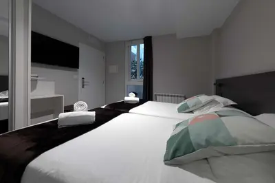 a large white bed in a room with a window at Kumano Kodo by Como en Casa in Santiago de Compostela