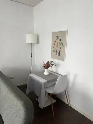 a white room with a table with a vase of flowers on it at Precioso apartamento a 1 minuto de la playa in Foz