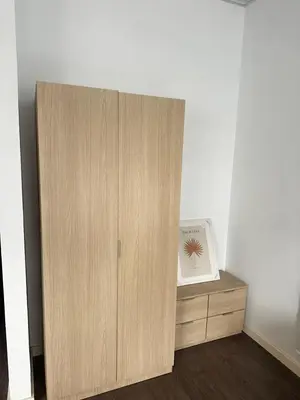 a wooden cabinet in a room with a clock at Precioso apartamento a 1 minuto de la playa in Foz