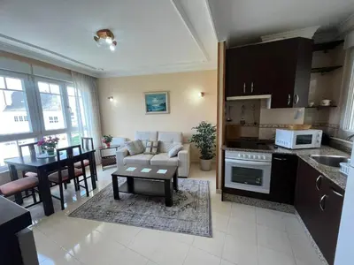 a kitchen and living room with a couch and a table at Apartamento Los Gallegos in Foz