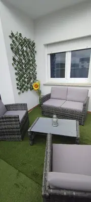 a patio with a couch and a table and a plant at Piso Altos de Foz in Foz