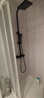 a shower with a black shower head in a bathroom at Piso Altos de Foz in Foz