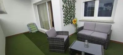 a balcony with two chairs and a table and a window at Piso Altos de Foz in Foz