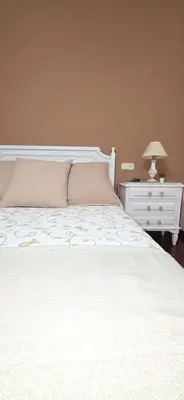 a bedroom with a white bed and a nightstand with a lamp at Amma Ribeira Sacra in Monforte de Lemos