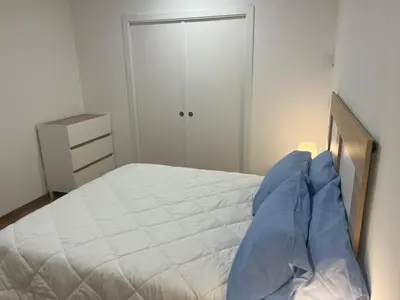 a bedroom with a large white bed with blue pillows at Vistas del Parque in Santiago de Compostela