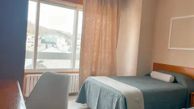 a bedroom with a bed and a large window at Casa Pazos, Pedrafita do Cebreiro in Piedrafita