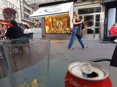 a woman walking down the street in front of a store at Habitación de lujo in Santiago de Compostela