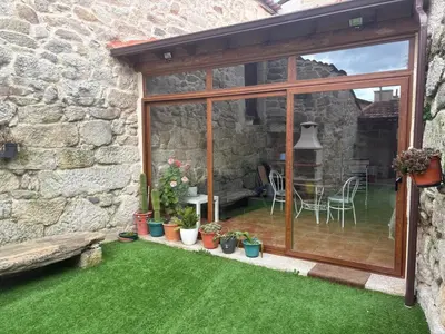 a garden with a window and a table and chairs at A casita das Pegas