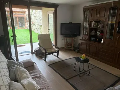a living room with a couch and a chair and a tv at A casita das Pegas