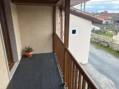 a porch with a potted plant on the side of a house at A casita das Pegas